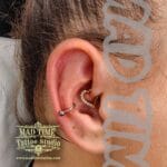 36Professional Piercing Liverpool home new ognialna zagubiona 36 kafelkow Professional daith piercing showcase at Mad Time Tattoo Studio, featuring an elegant gold heart hoop jewelry piece with inlaid clear crystals on the inner ear cartilage, paired with a titanium conch hoop ring on a female client.