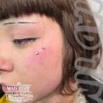 36Professional Piercing Liverpool home new ognialna zagubiona 36 kafelkow Professional anti-eyebrow surface piercing showcase by Mad Time Tattoo Studio, featuring two flat crystal microdermal anchors placed below the outer corner of a female client's eye.