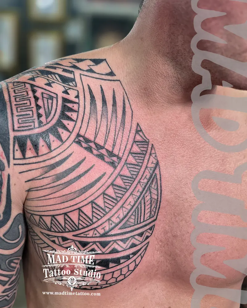 Traditional Polynesian tribal tattoo covering the shoulder and pectoral muscle of a man.