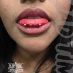 36Professional Piercing Liverpool home new ognialna zagubiona 36 kafelkow • Professional snake eyes tongue piercing showcase at Mad Time Tattoo Studio, featuring a horizontal tongue tip piercing with symmetrical gold-anodized titanium ball ends on a client.