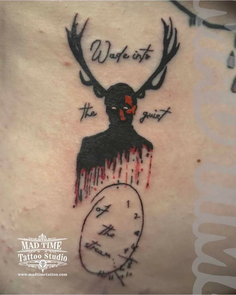 Blackwork graphic tattoo of a stag deer head with massive antlers and a melting pocket watch below.