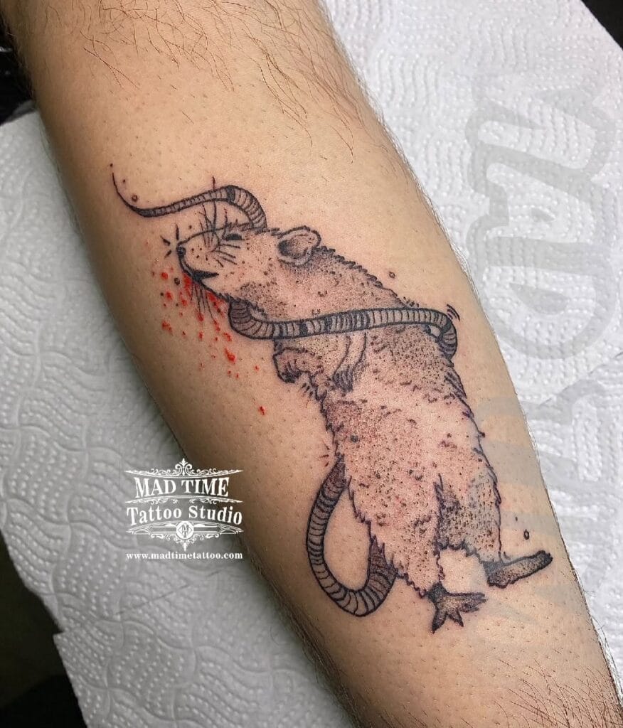 Sketch style blackwork tattoo of a rat or mouse with fine lines and textured shading on an arm.