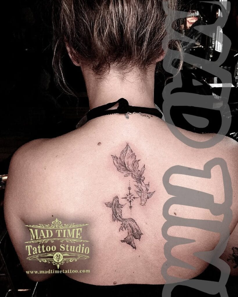 Minimalist fine line tattoo of two koi fish swimming up the upper back and spine of a woman.