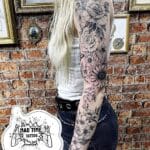 Home new Full sleeve fine line tattoo for women featuring a seamless flow of detailed flowers and leaves from shoulder to wrist