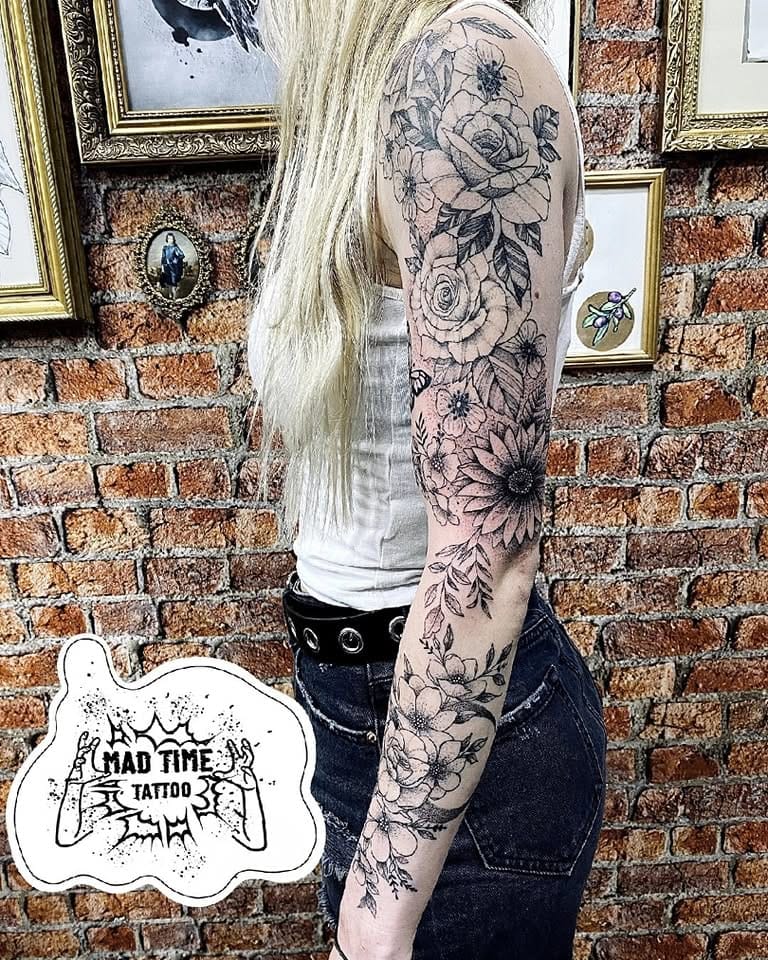Full sleeve fine line tattoo for women featuring a seamless flow of detailed flowers and leaves from shoulder to wrist