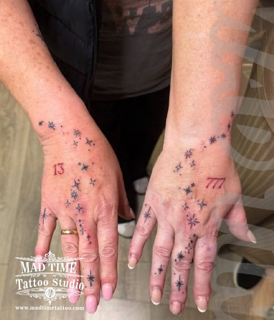 Micro fine line constellation and geometric dot work tattoo scattered across both hands and fingers.