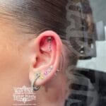 36Professional Piercing Liverpool home new ognialna zagubiona 36 kafelkow Professional flat piercing showcase by Mad Time Tattoo Studio, featuring an elegant dangling bow stud with a hanging clear crystal on the upper ear flat cartilage, paired with multiple lobe piercings on a female client.