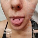 36Professional Piercing Liverpool home new ognialna zagubiona 36 kafelkow Professional frog eyes tongue piercing showcase at Mad Time Tattoo Studio, featuring symmetrical black acrylic or titanium mini beads on the tip of a female client's tongue.