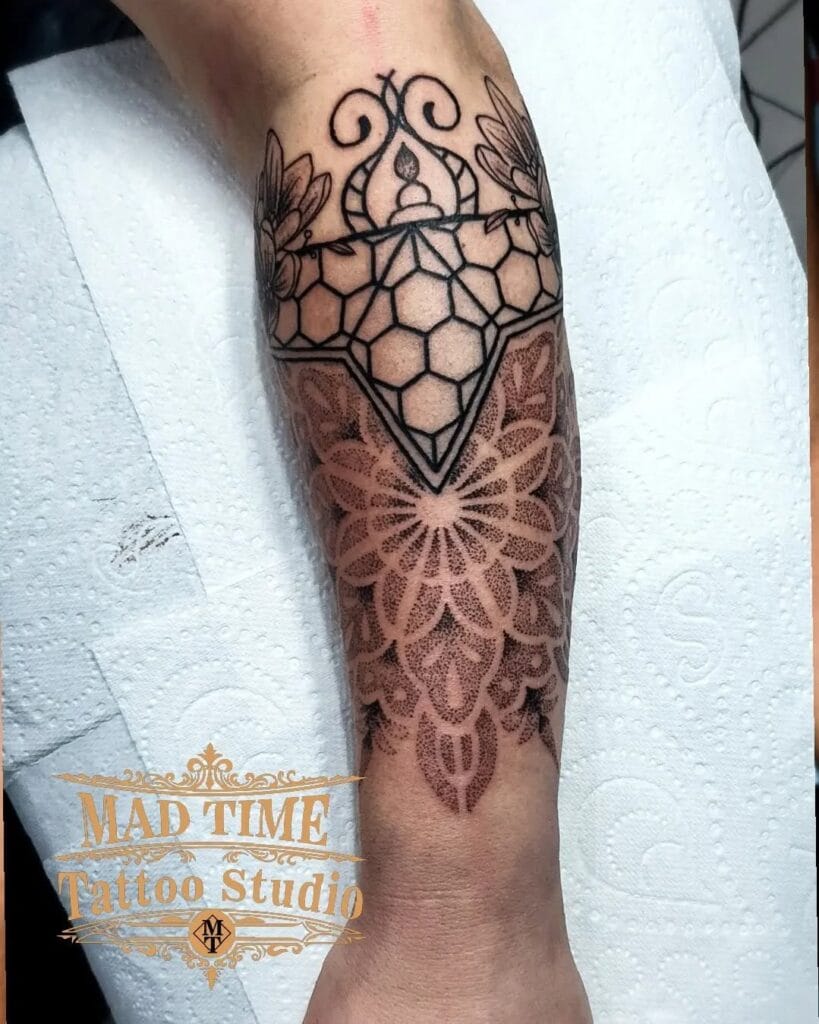 Blackwork and dotwork forearm sleeve tattoo on a client featuring a solid geometric crystal framework transitioning into a highly detailed stipple mandala near the wrist.