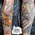 Home new Matching traditional Japanese leg sleeve tattoos by Mad Time Tattoo, featuring a colorful orange Koi fish with a lotus flower on one calf, and a Japanese Hannya mask with wind spirals and Kanji script on the other.