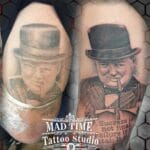 Home new Before and after comparison of a realistic black and grey Winston Churchill portrait tattoo retouch by Mad Time Tattoo, featuring enhanced facial shading, deep contrast, a cigar, and a famous quote block on an arm.