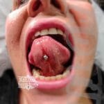 36Professional Piercing Liverpool home new ognialna zagubiona 36 kafelkow Professional tongue web piercing showcase by Mad Time Tattoo Studio, featuring a titanium curved barbell precisely placed through the tongue frenulum of a female client.