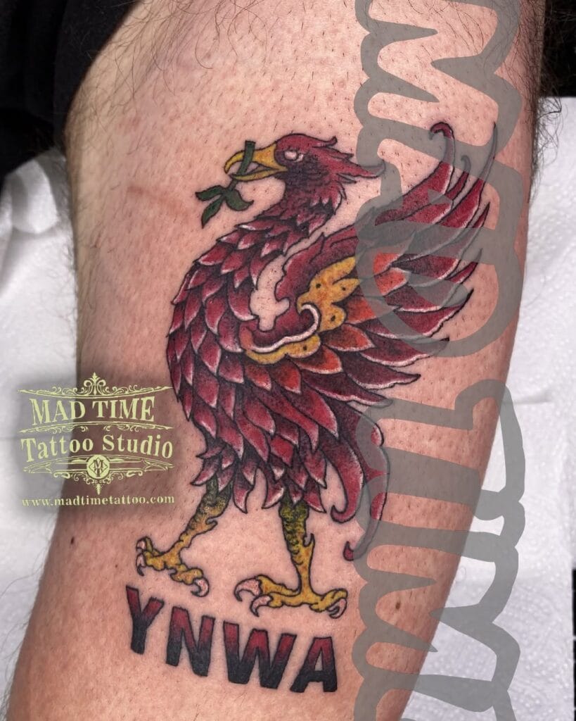 Large neo-traditional colorful thigh tattoo of the Liver Bird holding a seaweed leaf in its beak.