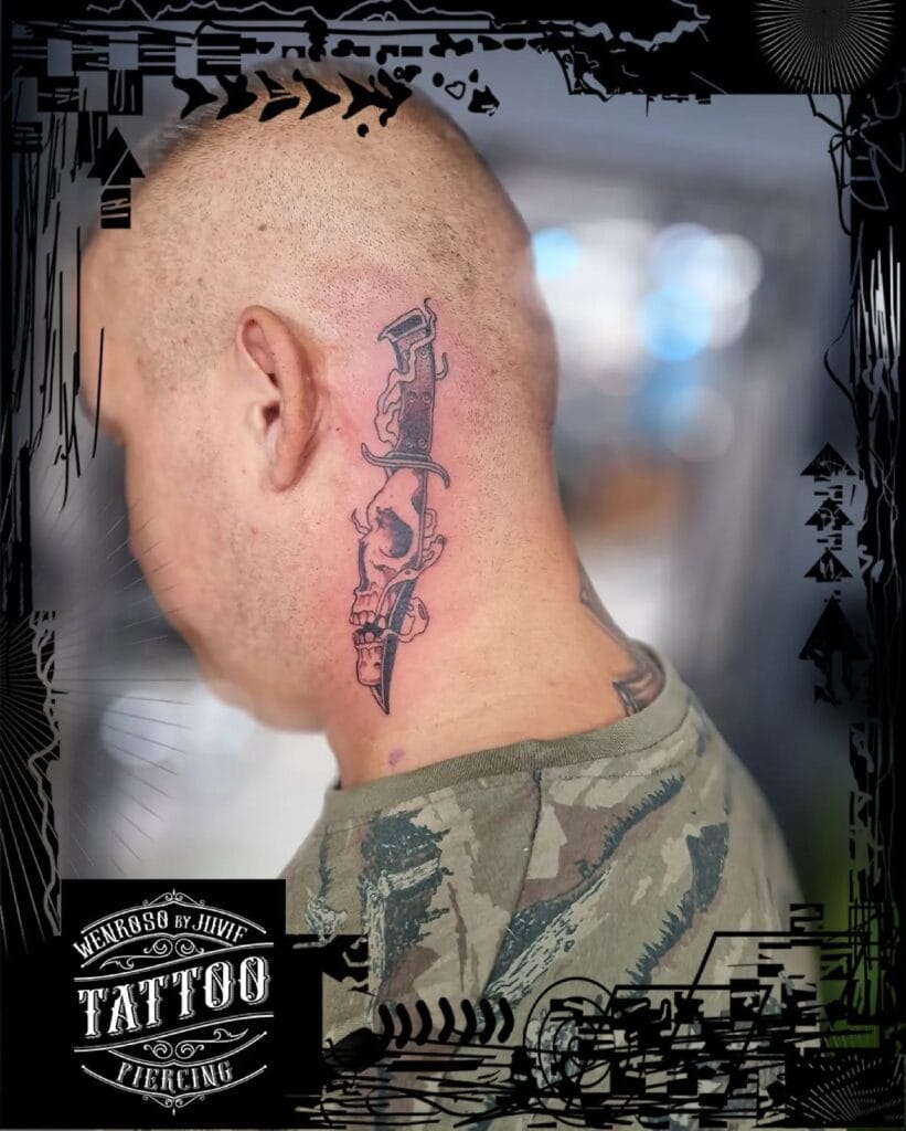 Traditional black and grey neck tattoo of a sharp dagger with a human skull detailed inside the blade, placed behind the ear.
