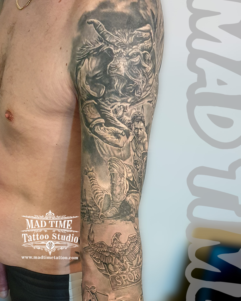 • Black and grey realism tattoo sleeve depicting a furious Minotaur battling a gladiator with a Roman SPQR eagle badge by Henry at our studio