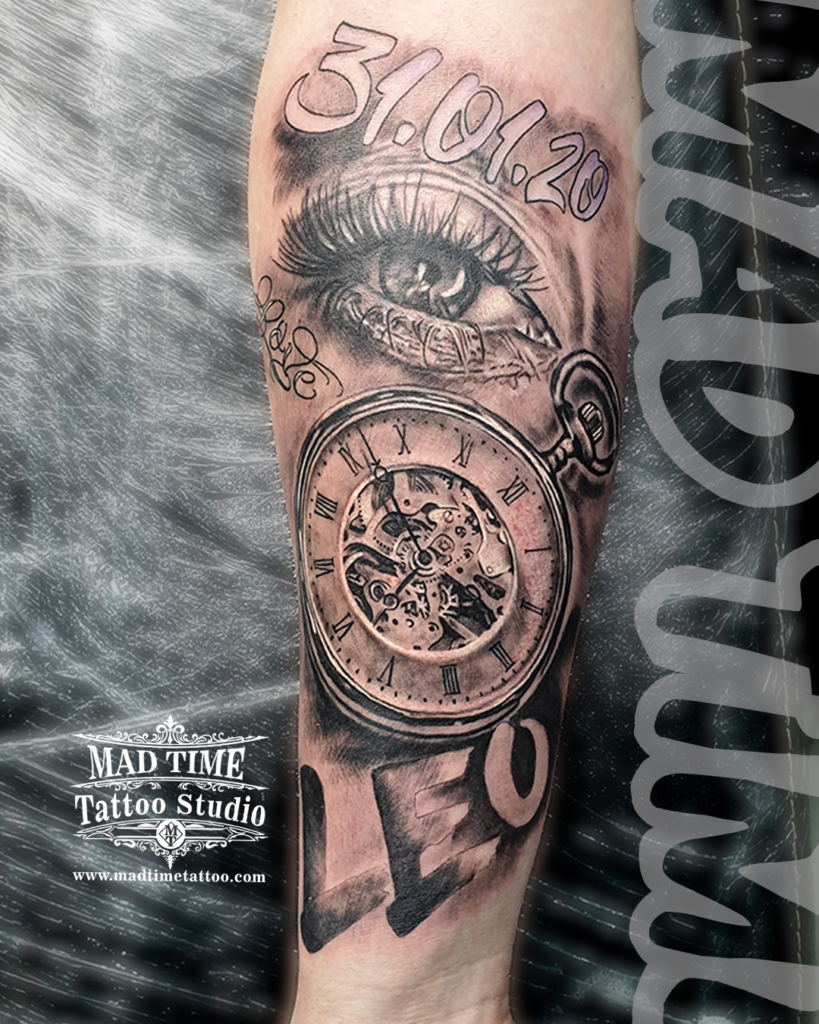 • Custom black and grey realism tattoo featuring a highly detailed open pocket watch mechanism an expressive crying eye the date 31.01.20 and Leo script by Henry at our studio