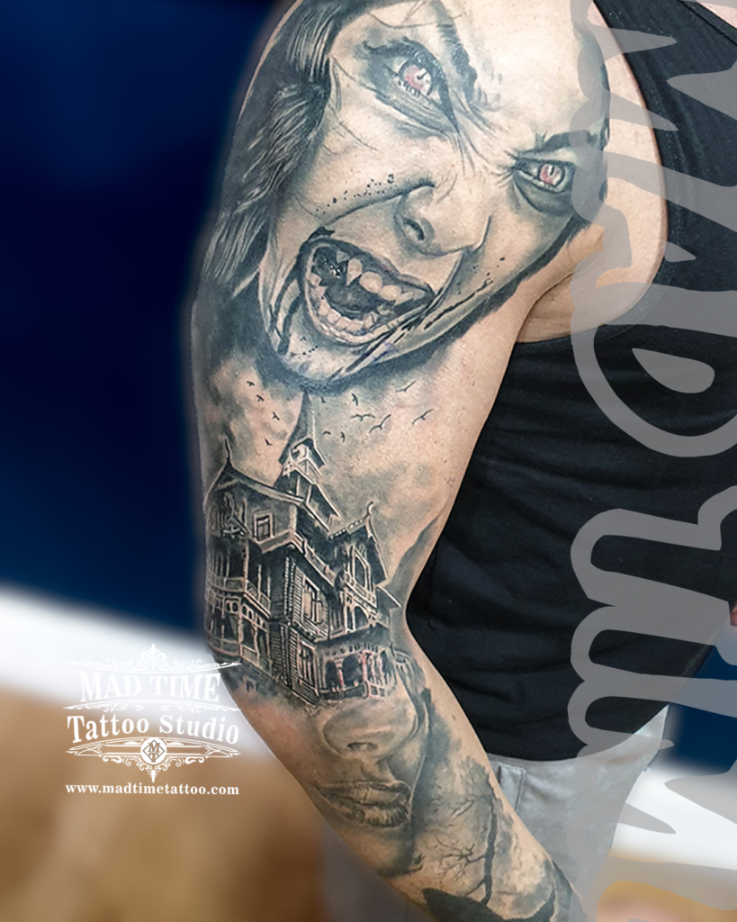 Dark gothic realism tattoo featuring a screaming vampire woman with fangs paired with a haunted Victorian house by Henry at our studio