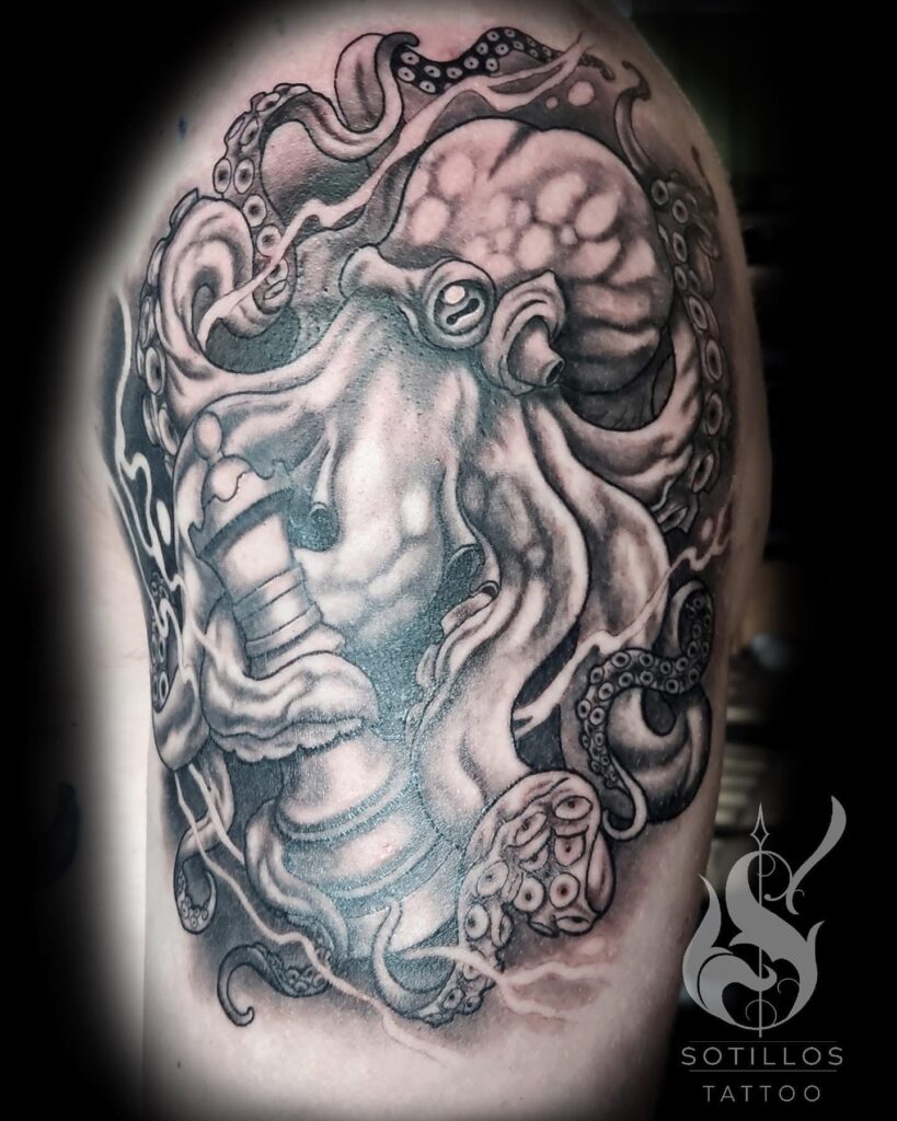 Black and grey shoulder tattoo of an intricate octopus wrapped around a lighthouse by guest artist Pablo from Spain at our studio