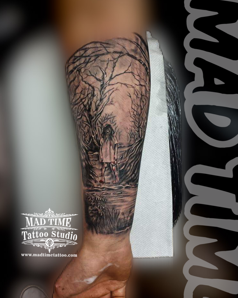 Dark horror realism forearm tattoo of Samara Morgan from The Ring walking down a spooky trail of dead winter trees by our studio