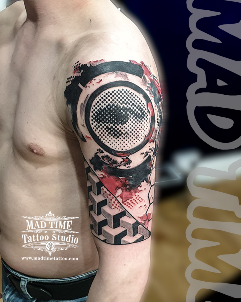 Large scale Trash Polka shoulder tattoo featuring a circular half tone dot eye pattern above 3D geometric optical illusion blocks and red ink accents by our studio