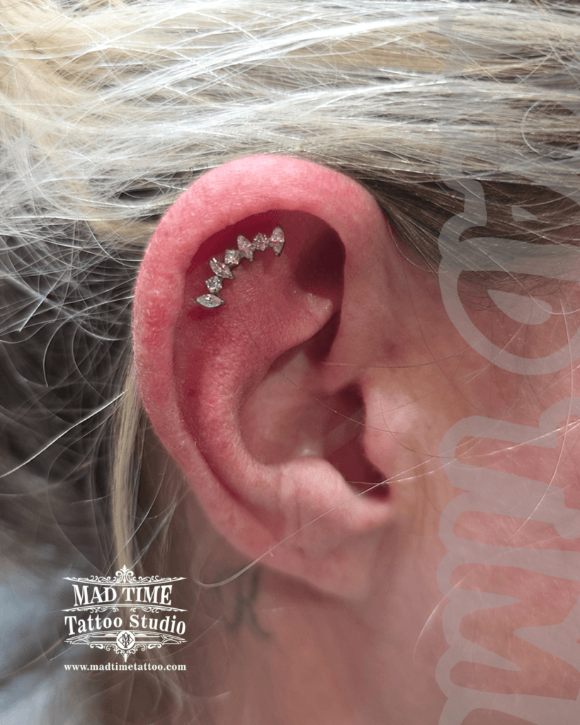 Silver flat helix piercing with a curved seven-stone marquise crystal cluster jewellery at Mad Time Tattoo Studio
