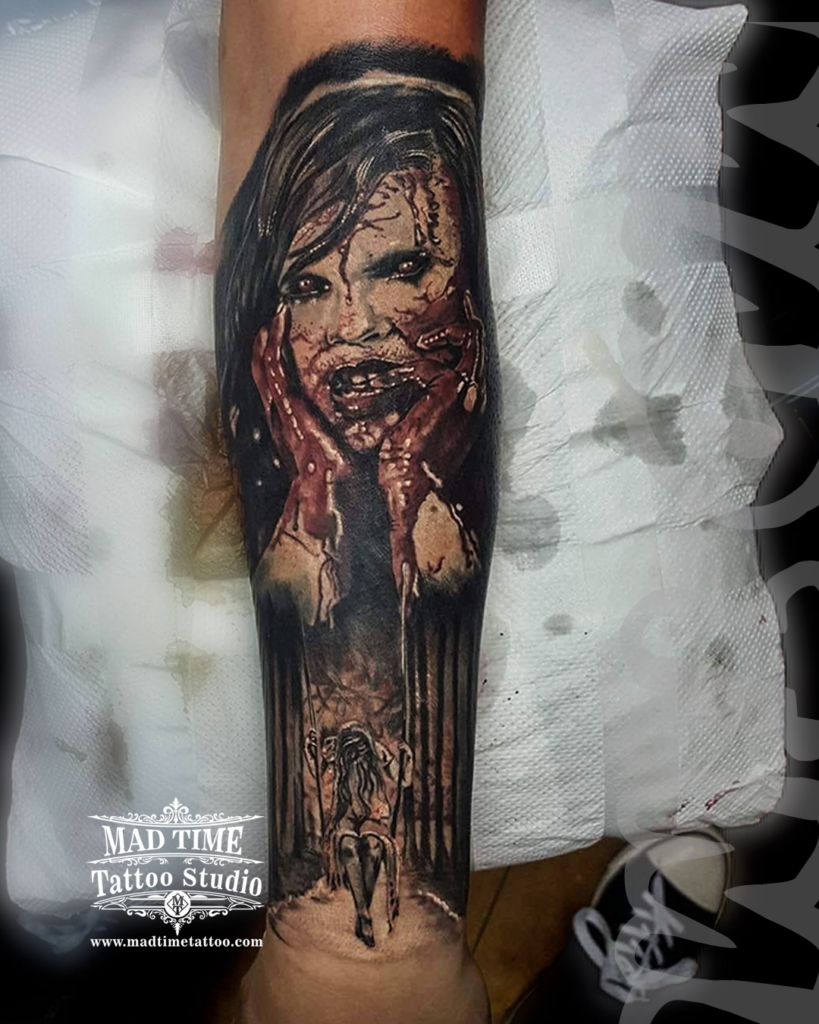 Evil Dead horror movie realism forearm tattoo of a blood-drenched deadite woman's face above a creepy girl on a swing by our studio